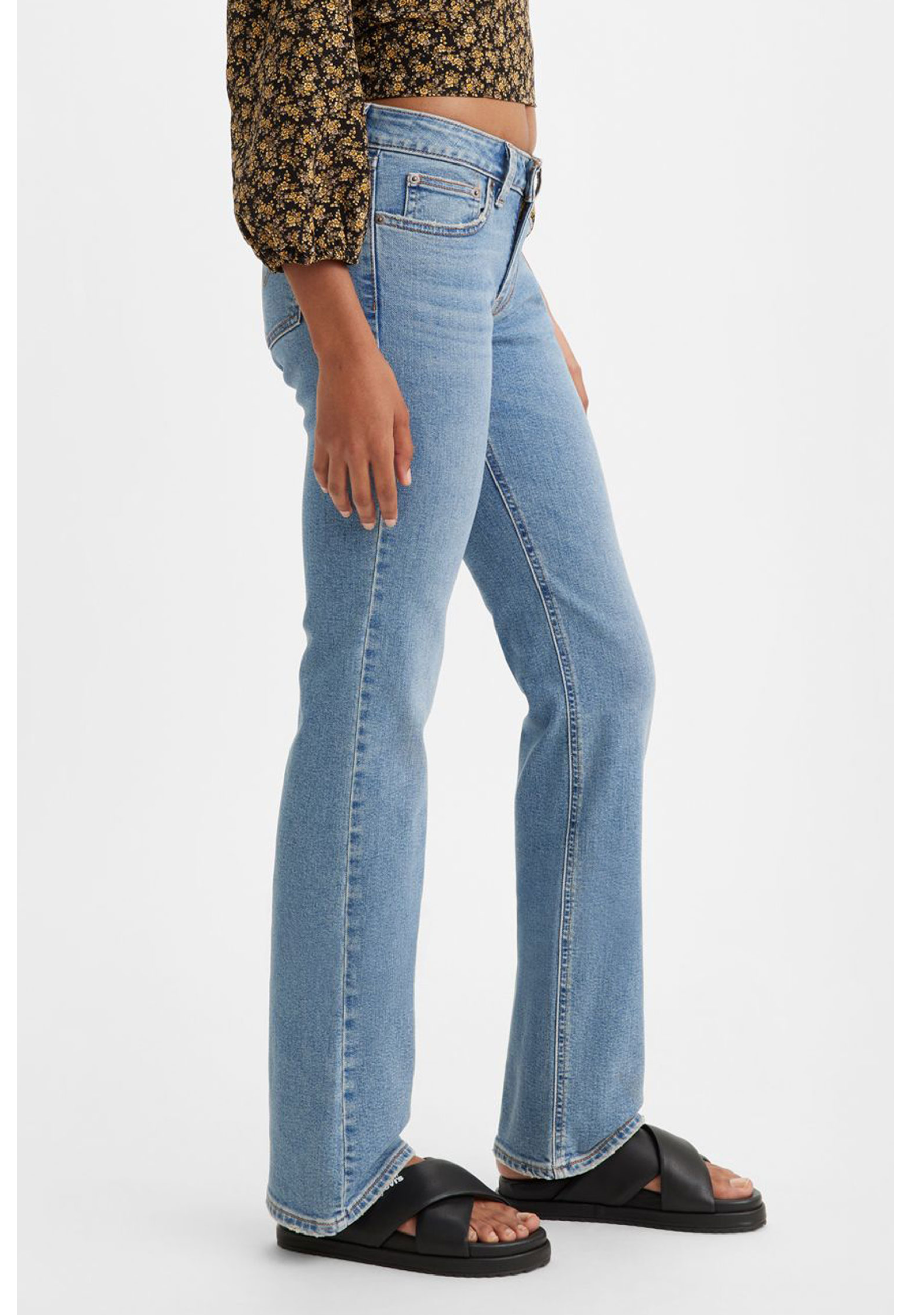 Жіночі джинси Levi's Superlow Bootcut Medium Wash у повсякденному образі з чоботами
