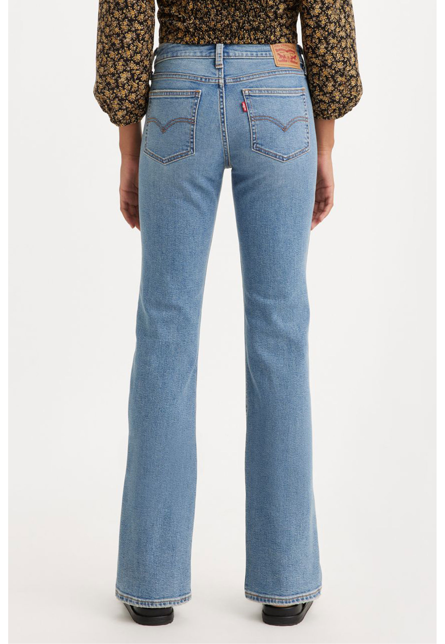 Жіночі джинси Levi's Superlow Bootcut Medium Wash у повсякденному образі з чоботами